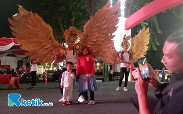 Thumbnail Dua anak kecil antusias berfoto bersama tim karnaval budaya Jawa Timur di sela-sela Gladi bersih Upacara 17 Agustus 2023, (16/8/2023). (Foto: Rifat/Ketik.co.id)