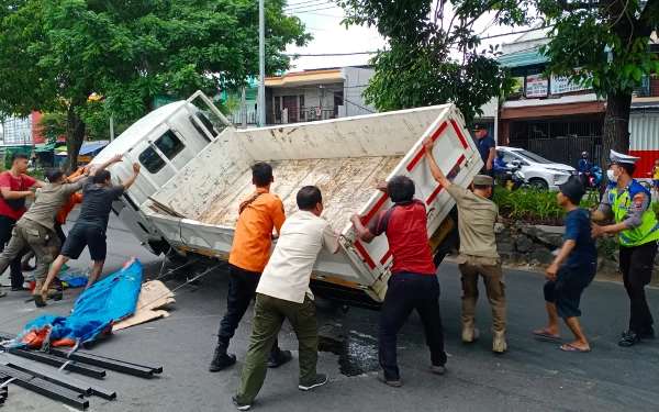 Hindari Mobil, Truk Muatan Besi Talang Terguling di Sukomanunggal Surabaya