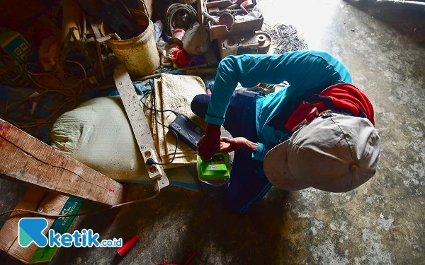 Thumbnail Sunari mencabut carger baterai traktor listrik yang sudah terisi penuh di Gudang Kelompok Tani Tulodo Markayo Desa Tlogoweru, Kecamatan Guntur, Kabupaten Demak, Jawa Tengah. Dalam kondisi kosong, baterai traktor listrik modifikasi PLN ini bisa diisi ulang hingga penuh dalam waktu 2,5 sampai 3 jam, dan dalam kondisi baterai penuh, traktor listrik dapat digunakan membajak sawah selama 5 hingga 6 jam. (Foto: Achmad Fazeri/Ketik.co.id)