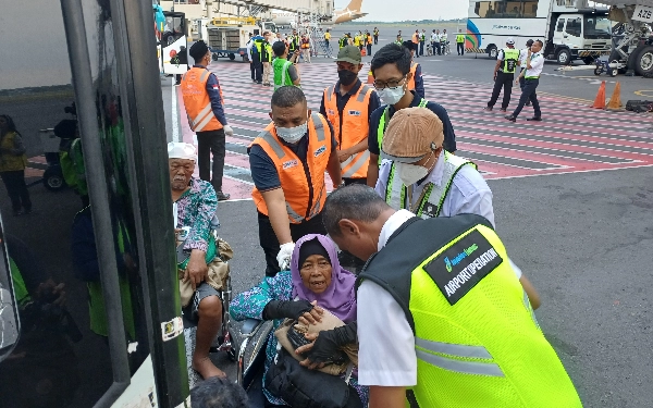 Thumbnail Petugas Bandara Internasional Juanda membantu jemaah haji masuk ke bus saat  tiba di Indonesia, Selasa (4/7/2023). (Foto : M.Khaesar/Ketik.co.id)