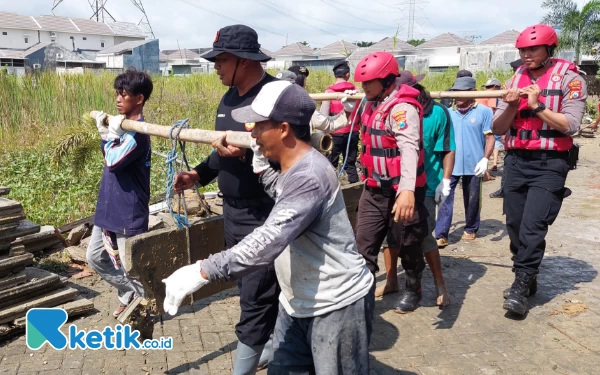 Thumbnail Berita - Warga Bantu Personel Kepolisian Membersihkan Rumah Genangan Banjir Driyorejo Gresik